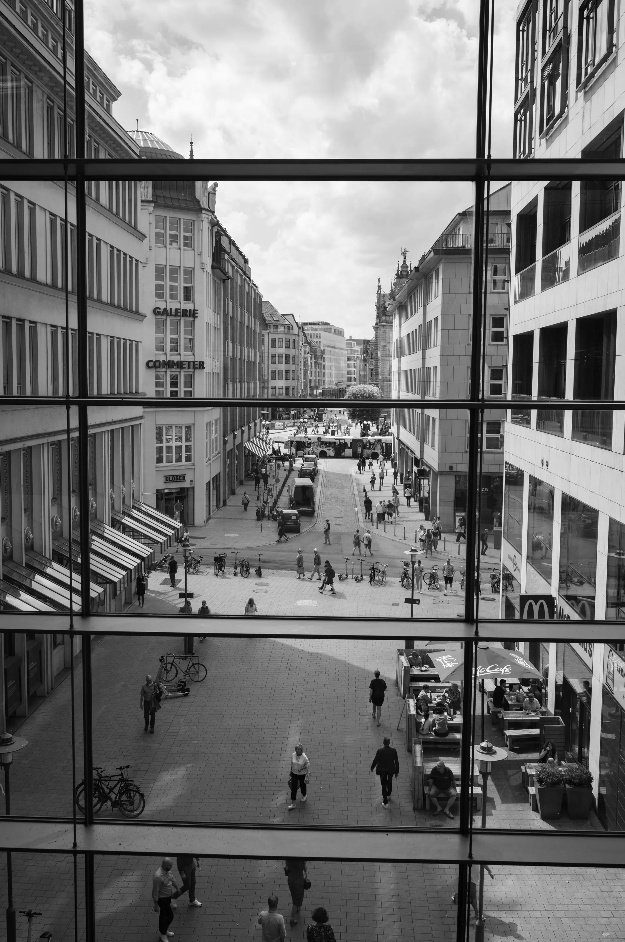 Fußgängerzone von oben, durch ein Raster aus Fensterrahmen gesehen